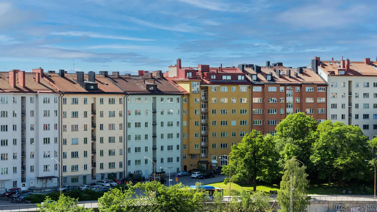 vy över grönska och bostadsrättshus i en stadsmiljö