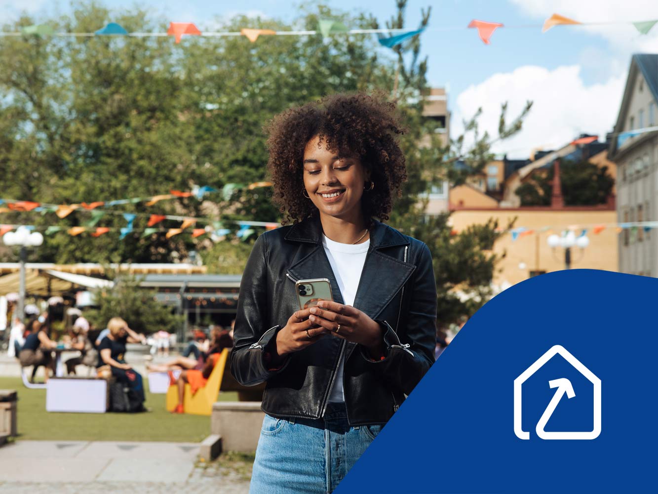 Glad kvinna står på ett torg och tittar i sin mobiltelefon. Ikon för framtidens fastighetsförvaltning.