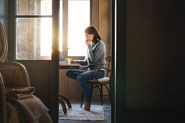 Kvinna som jobbar hemifrån sitt kök