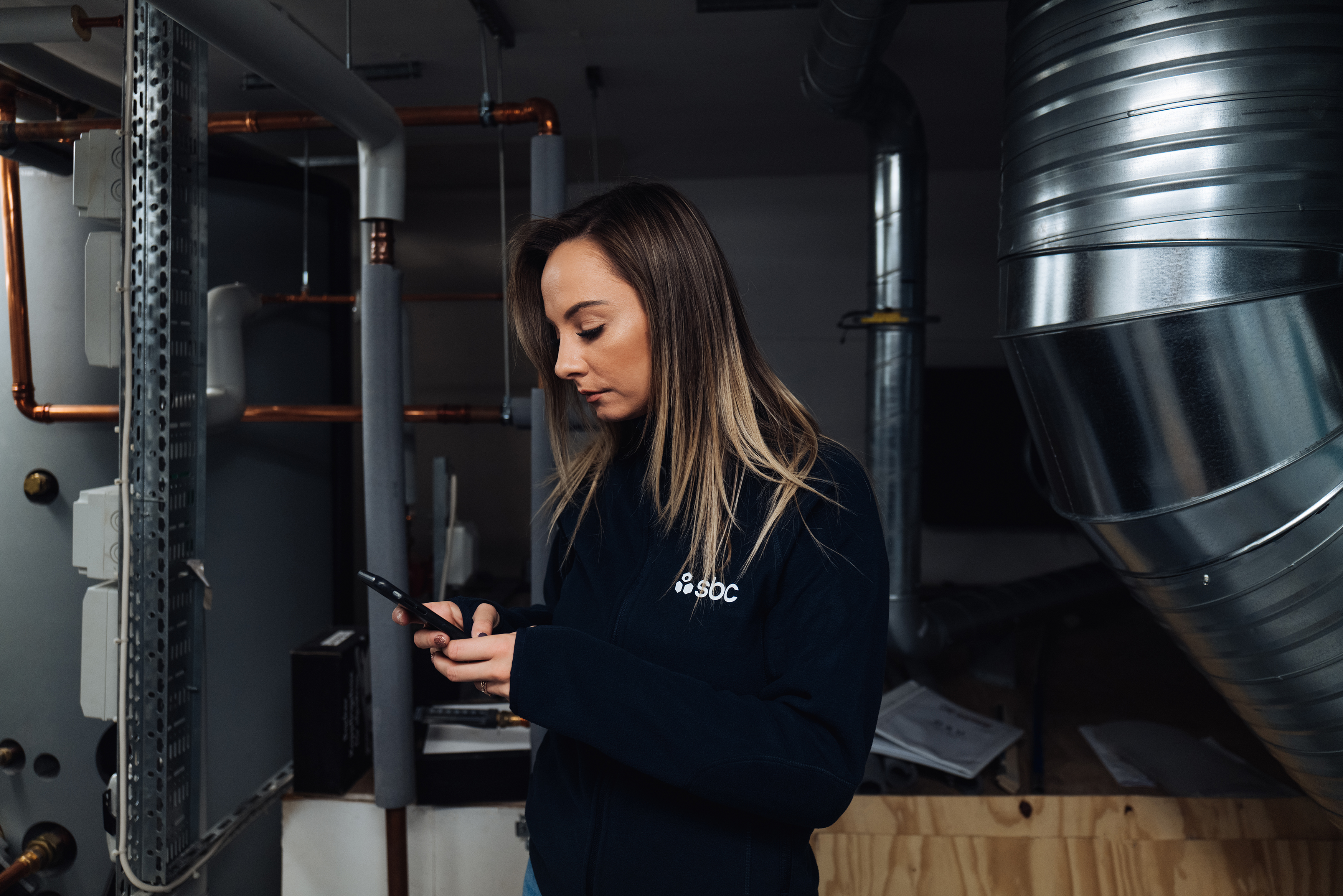 Teknisk förvaltare från SBC gör anteckningar i mobilen