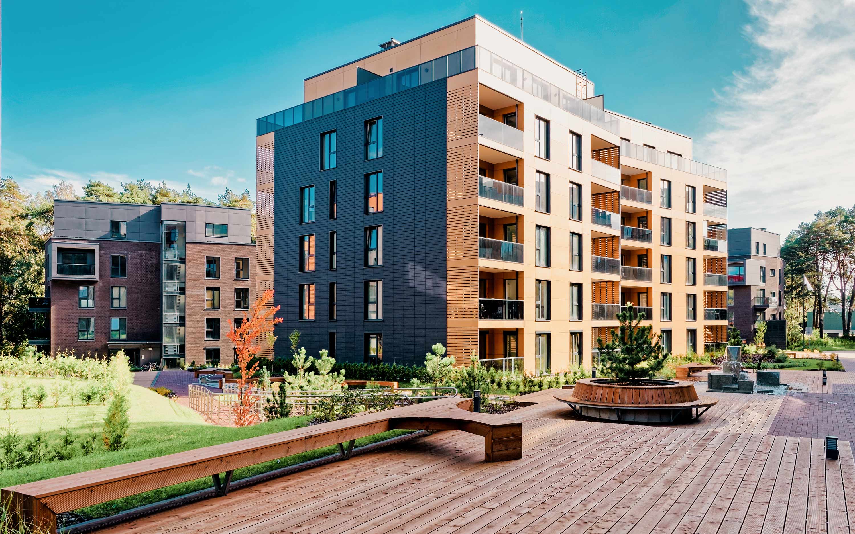 Modernt flerbostadshus med flera våningar och balkonger och utomhusanläggning